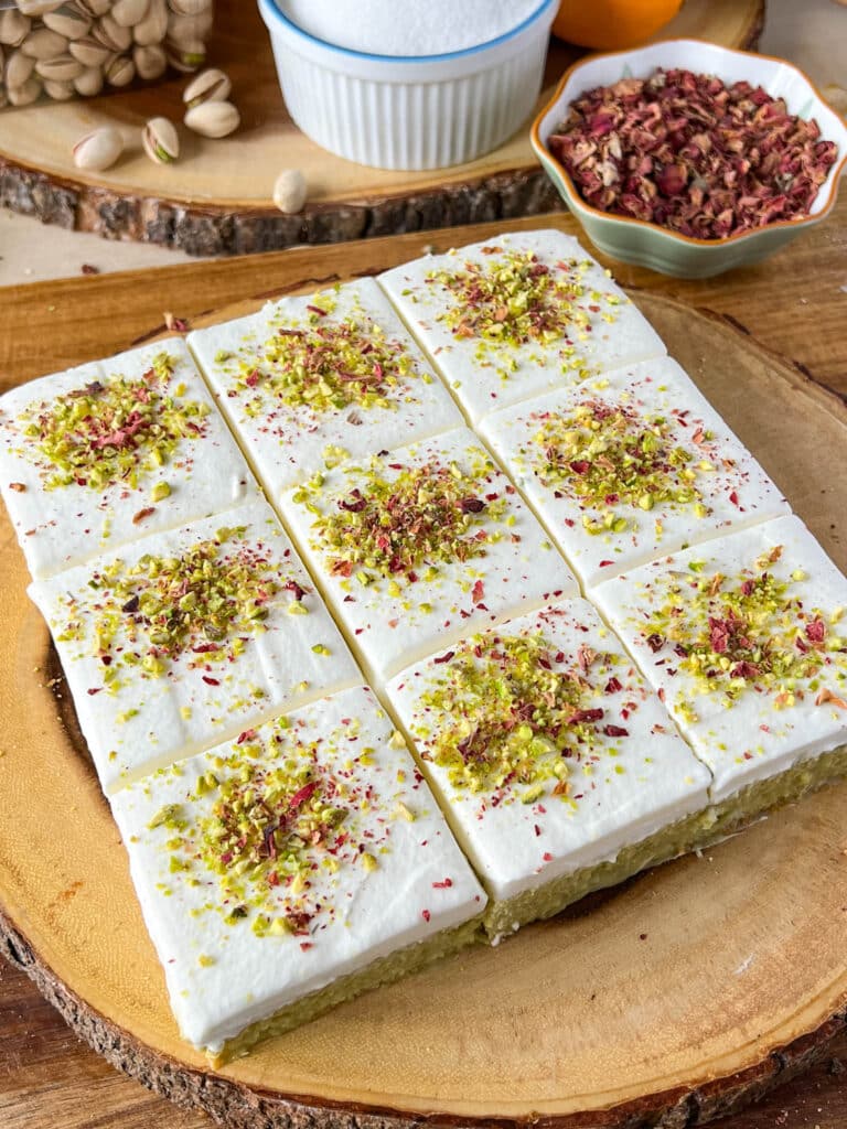 pistachio tres leches cake with rose petals and pistachio on it