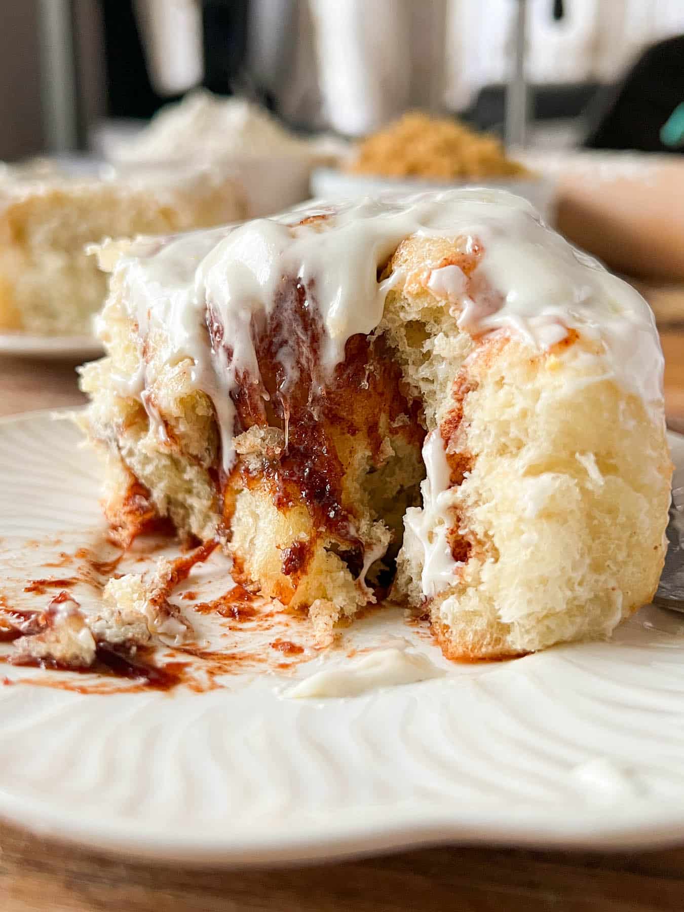 a gooey cinnamon roll cut into on a white plate