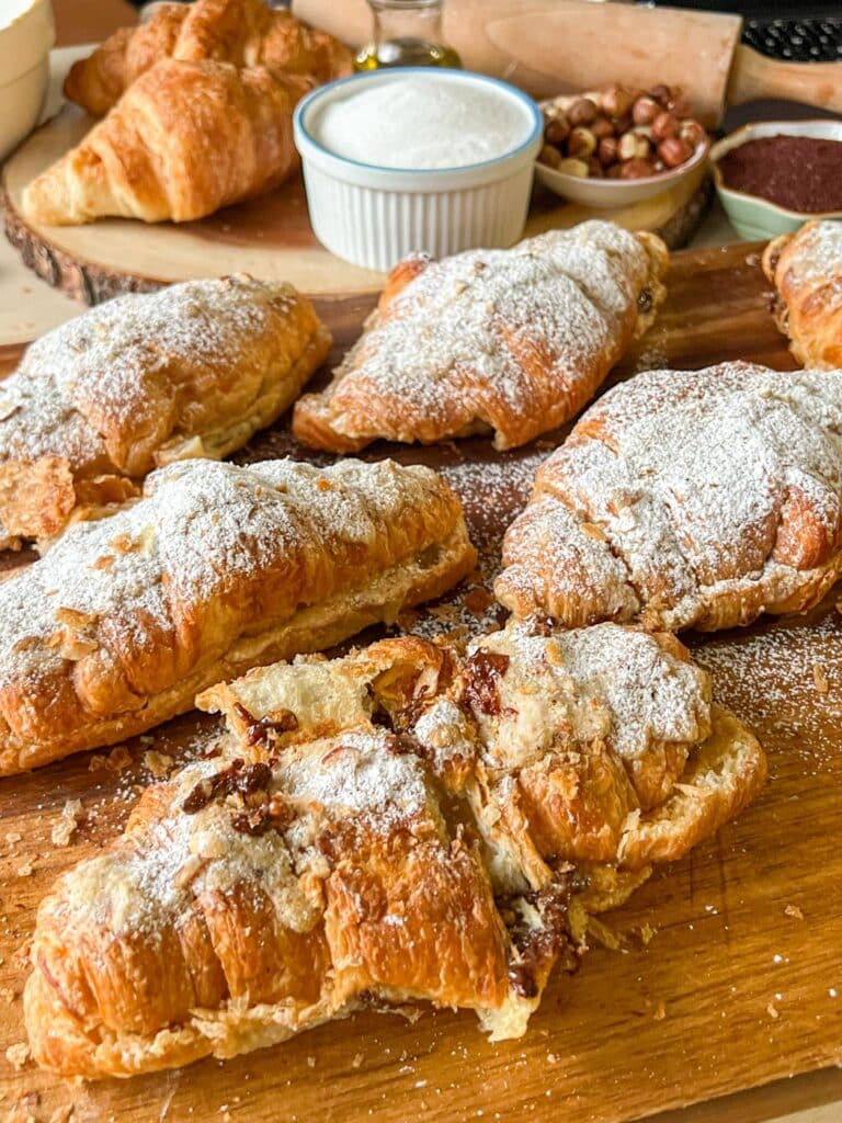 chocolate hazelnut croissants on a tray with one broken in half