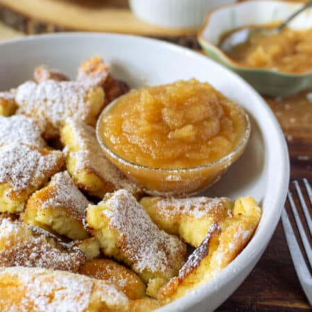 shredded pancakes on a plate with a small side of apple sauce