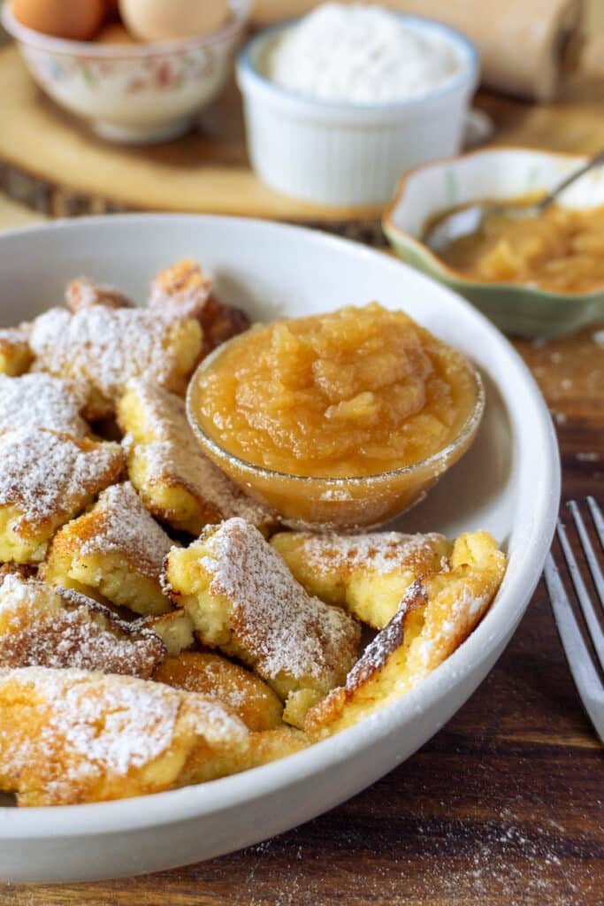 shredded pancakes on a plate with a small side of apple sauce