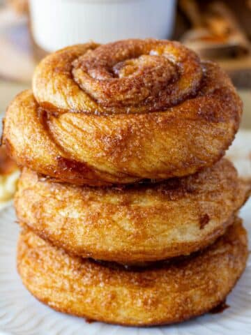 3 dutch cinnamon rolls stacked on a white plate