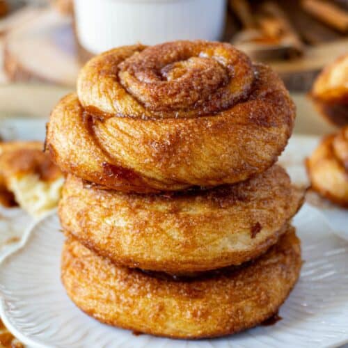 3 dutch cinnamon rolls stacked on a white plate