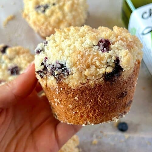 a hand holding a blueberry muffin