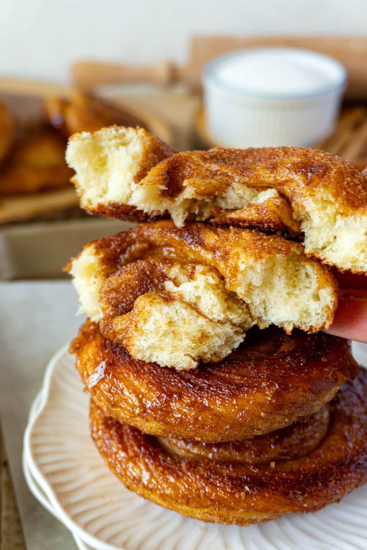 cinnamon roll ripped in half and stacked on 2 others on a plate