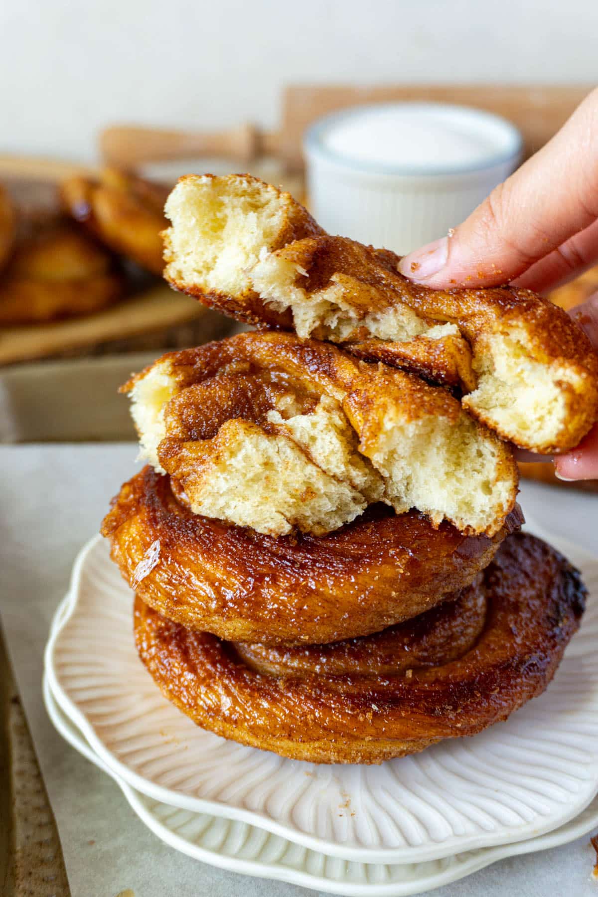 cinnamon roll ripped in half and stacked on 2 others on a plate