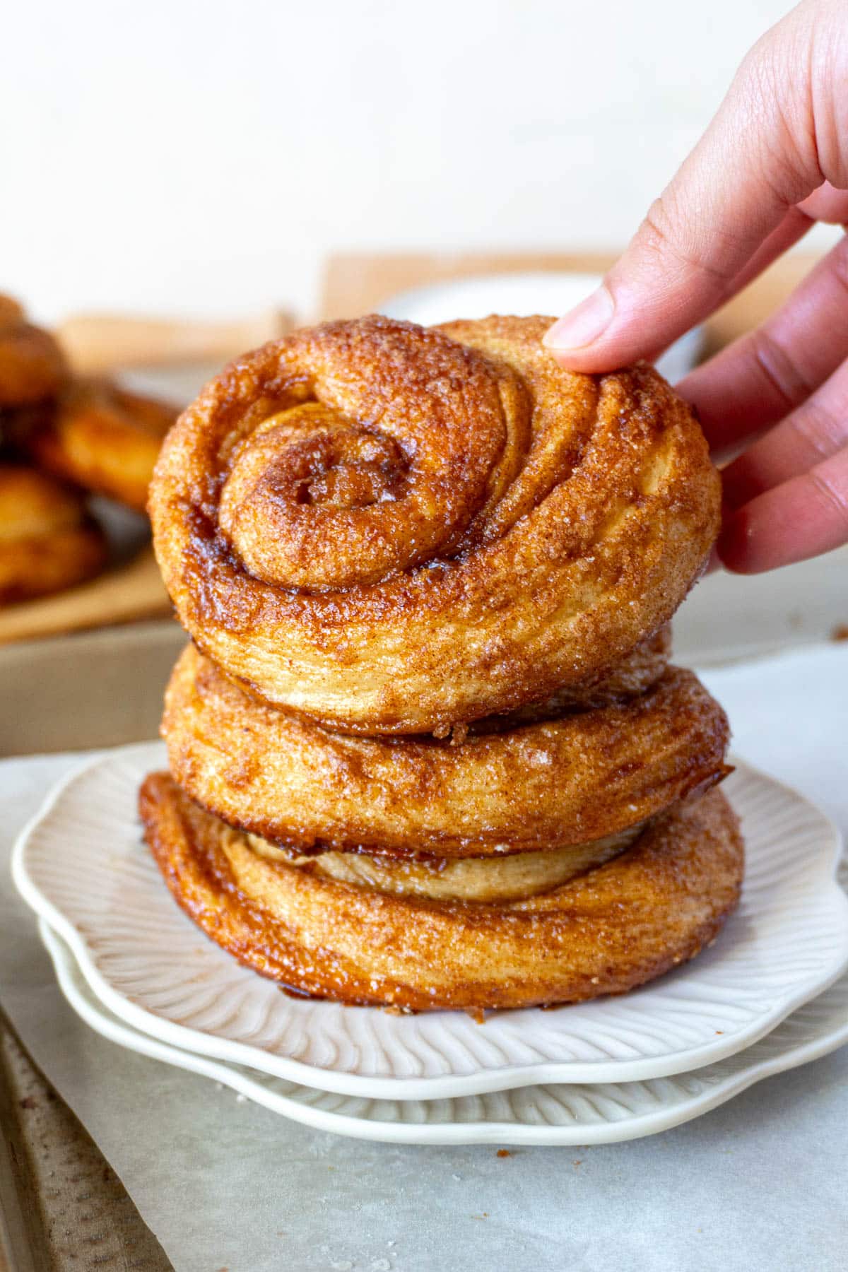 3 dutch cinnamon rolls stacked on a white plate