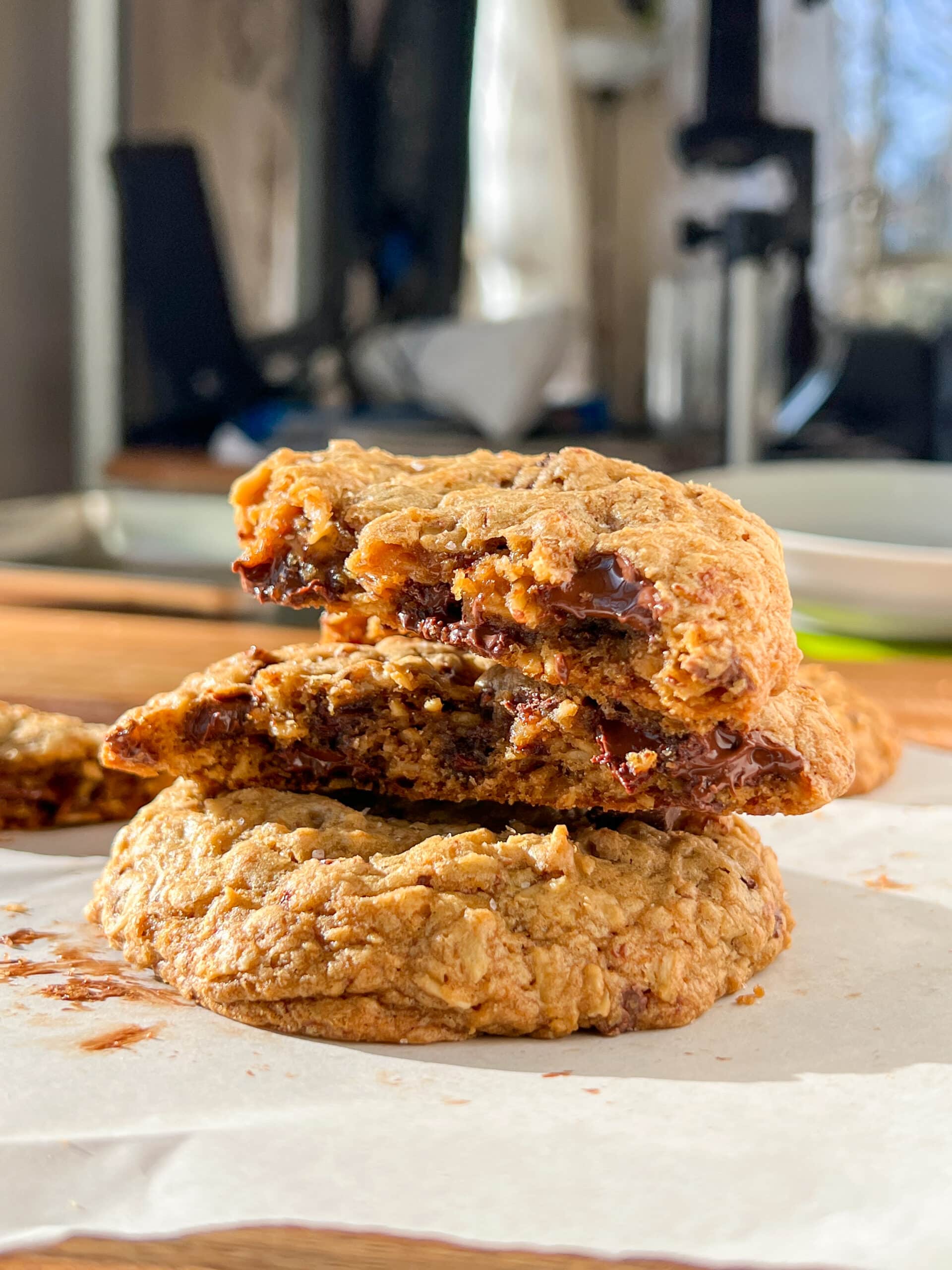 Oatmeal chocolate chip cookies stacked with the top two broken in half