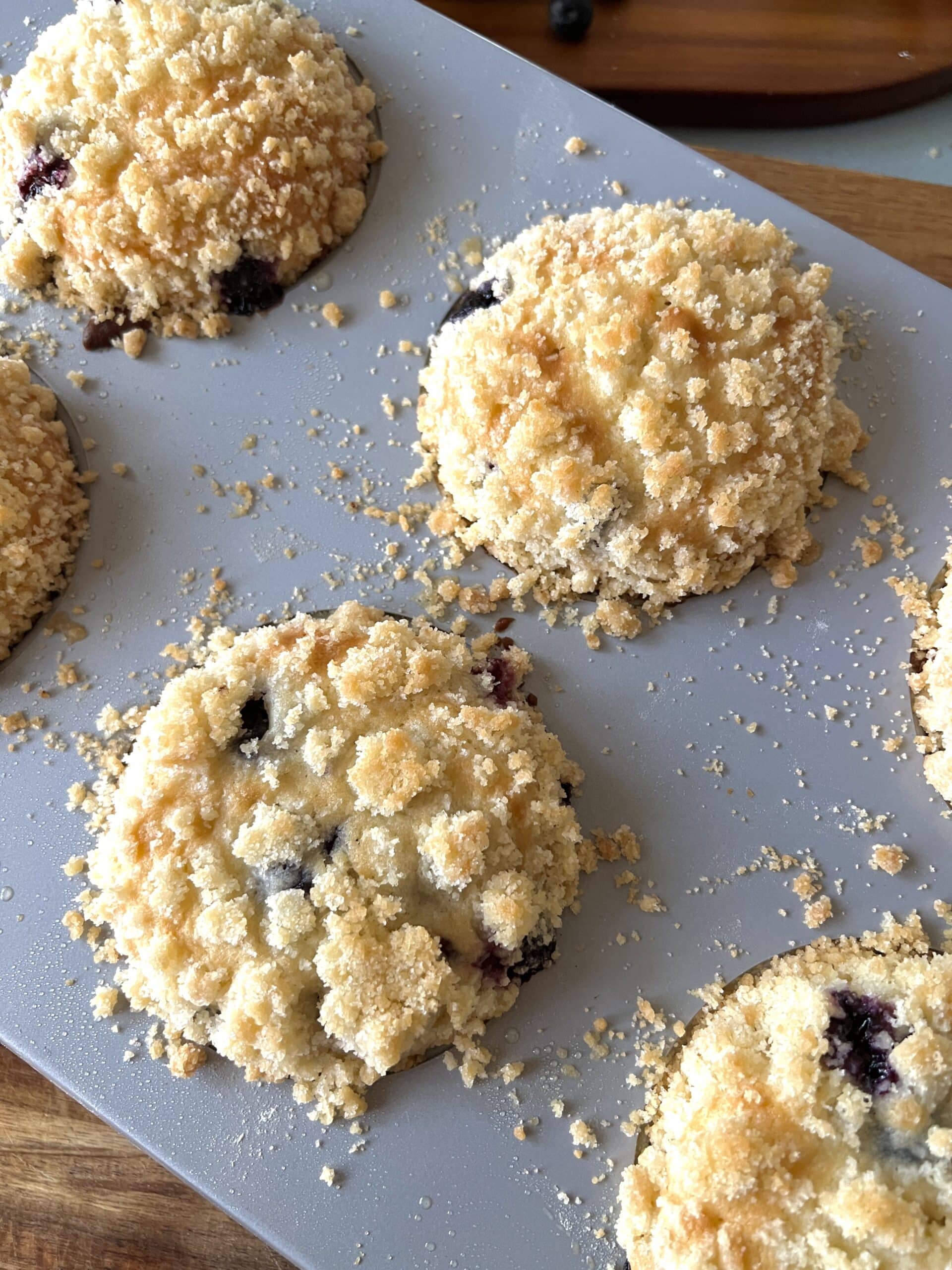 blueberry muffins with crumble in a muffin pan