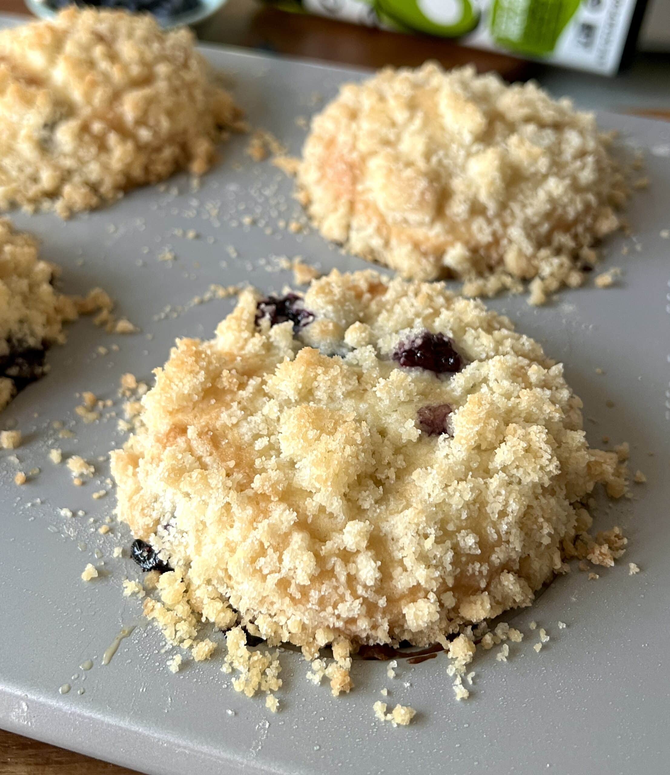 blueberry muffins with crumble in a muffin pan