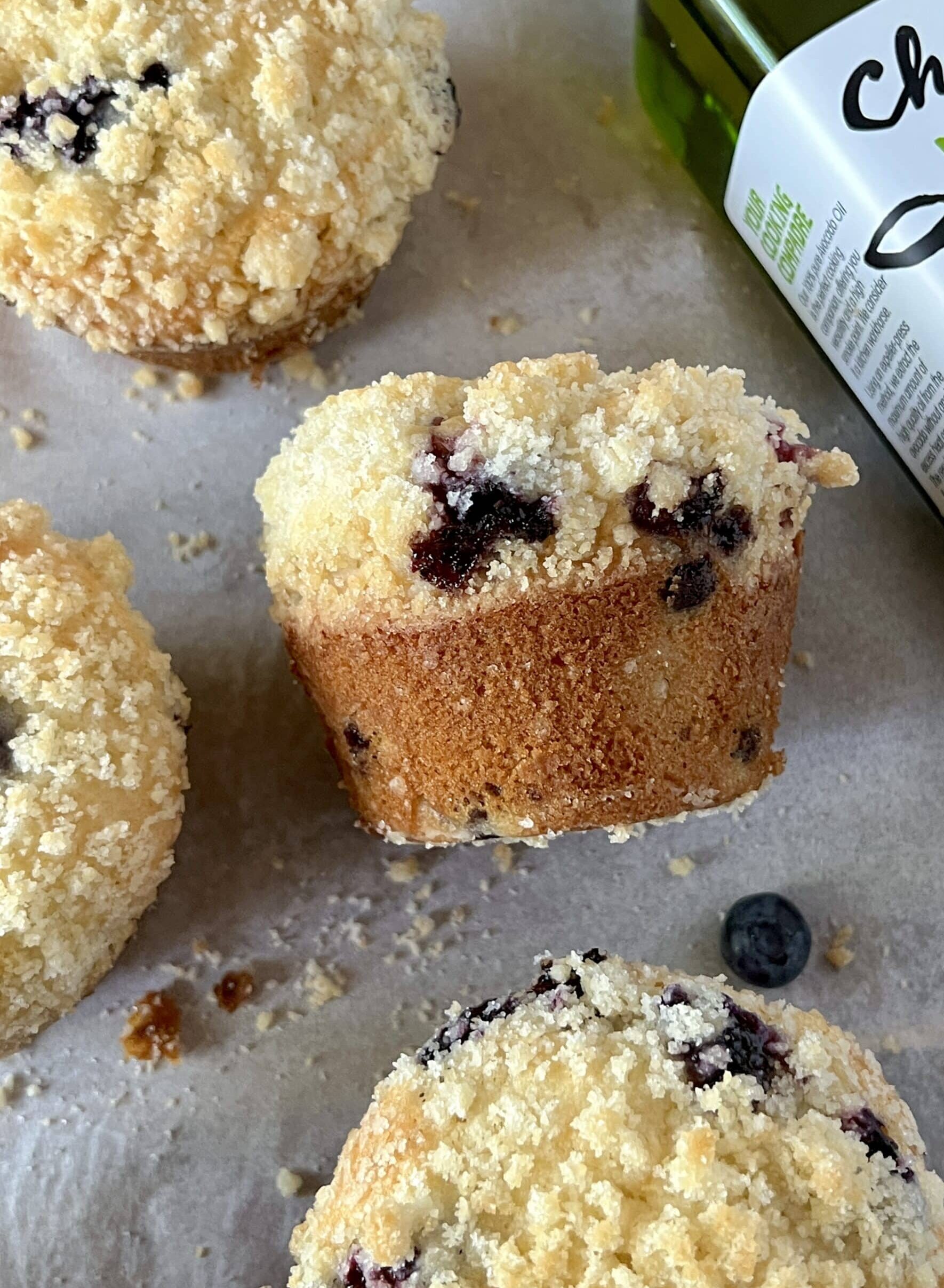 blueberry muffins with crumble on a gray surface