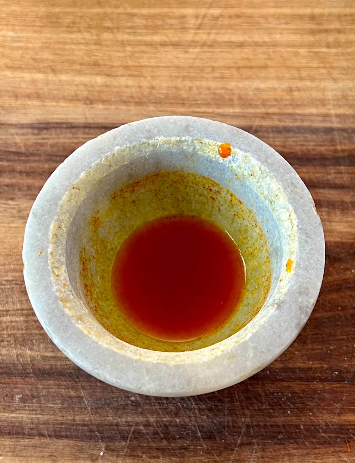 saffron being steeped with water, in a mortar