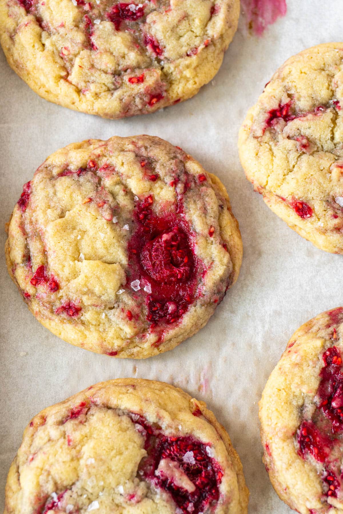 3 vanilla raspberry cookies in a row on a pan