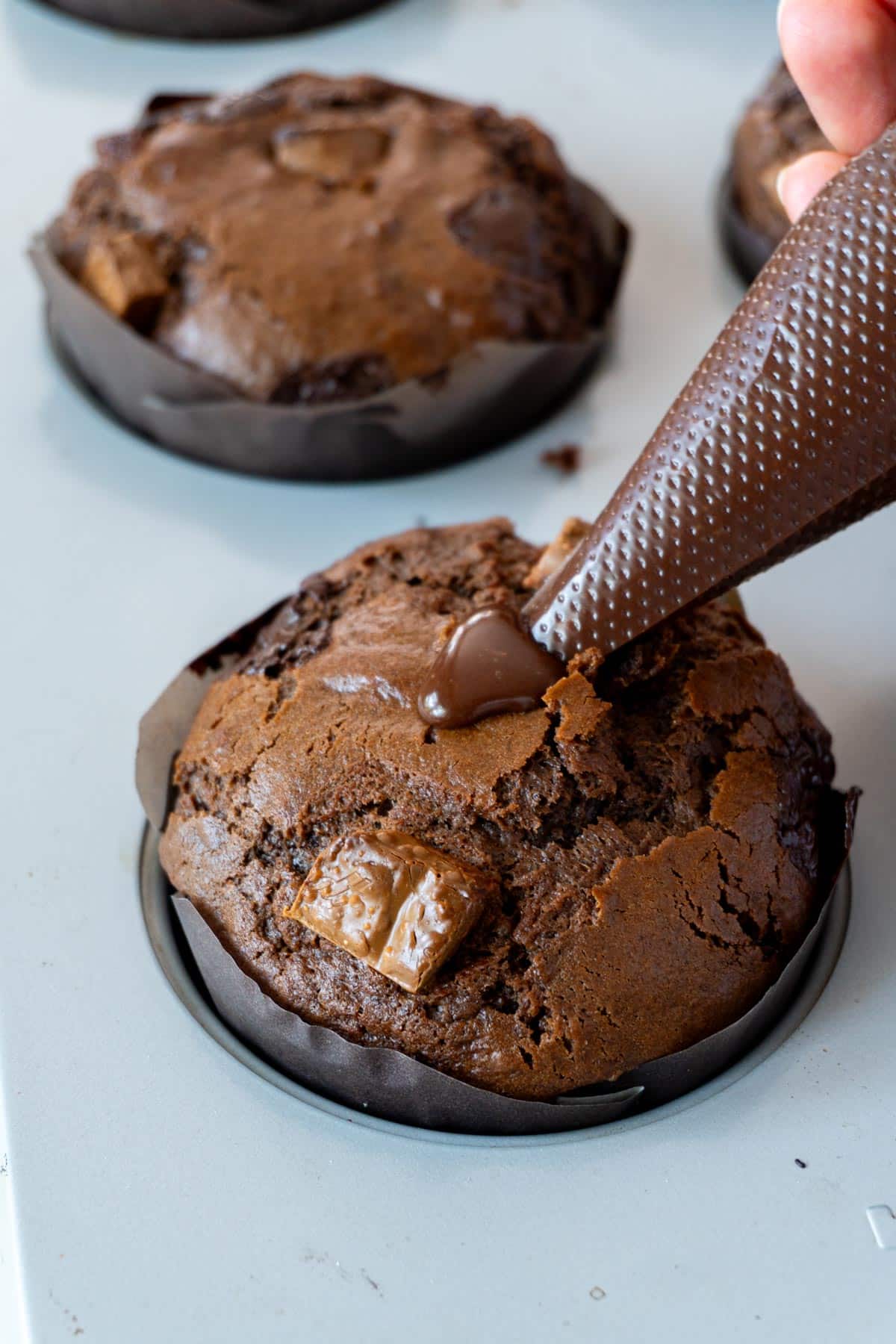 Piping chocolate ganache into muffins