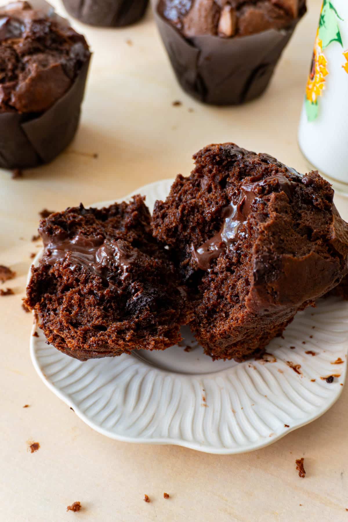 Olympic Double Chocolate Muffin filled with ganache, broken on half on a white plate