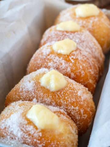 bomboloni or italian donuts lined up in a pan