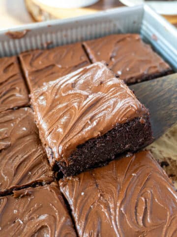 a slice of chocolate sheet cake being lifted from a pan