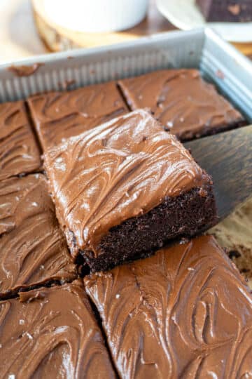 a slice of chocolate sheet cake being lifted from a pan