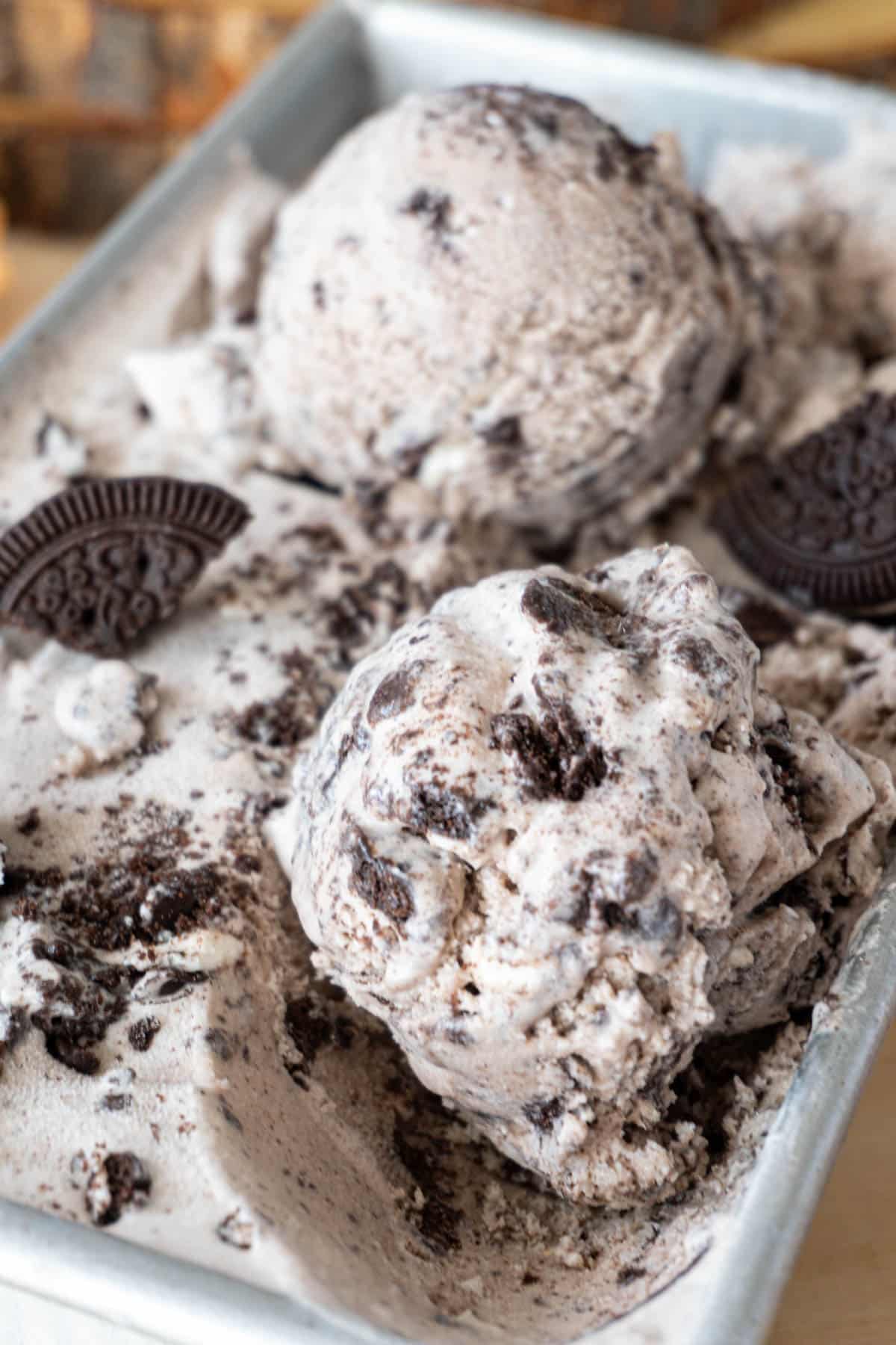 two scoops of cookies and cream ice cream in a container 