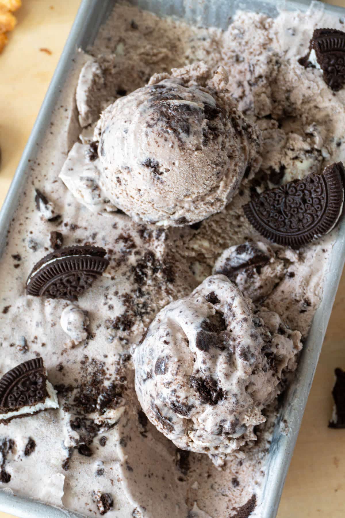 two scoops of cookies and cream ice cream in a container 