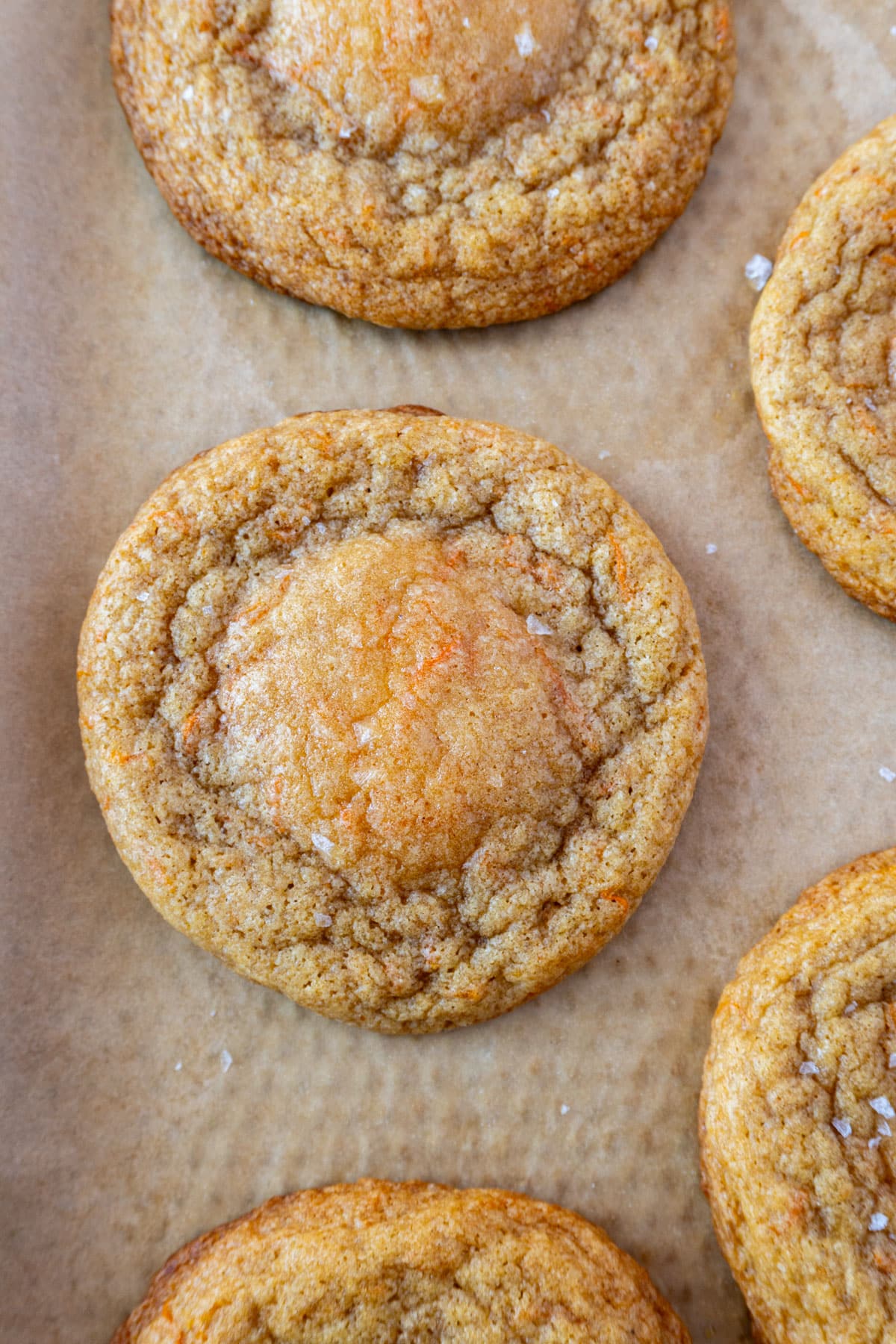 carrot cake cookies on a pan, lined with brown parchment paper 