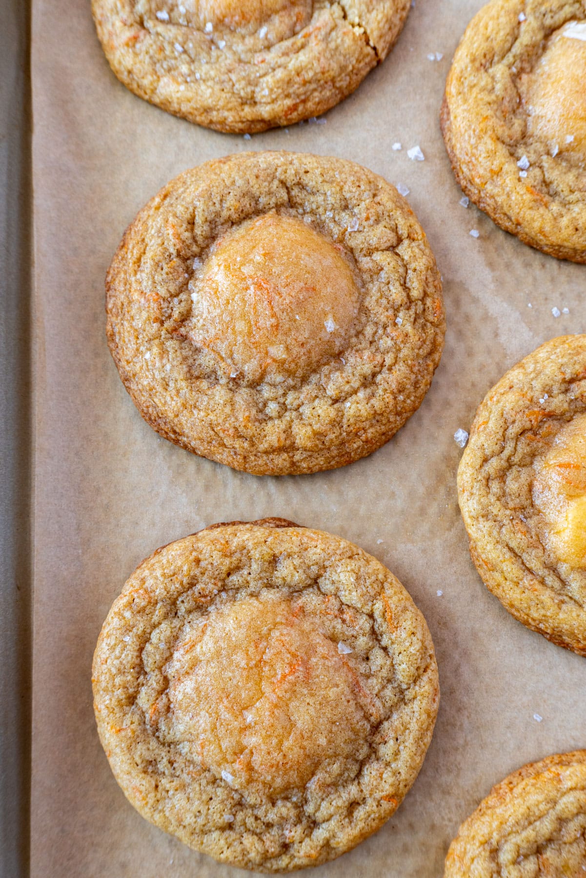 carrot cake cookies on a pan, lined with brown parchment paper