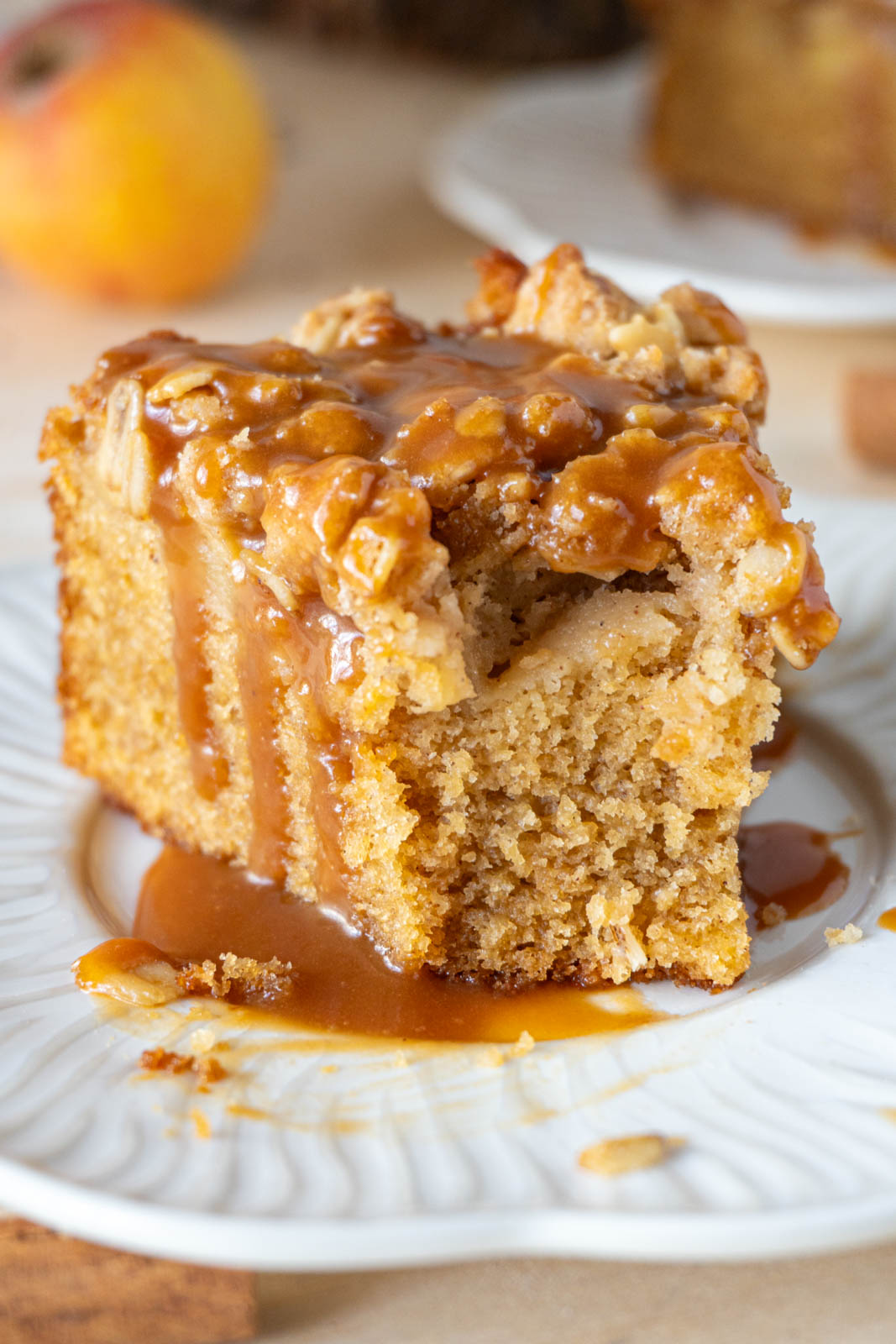 A slice of apple crumble cake, on a white plate