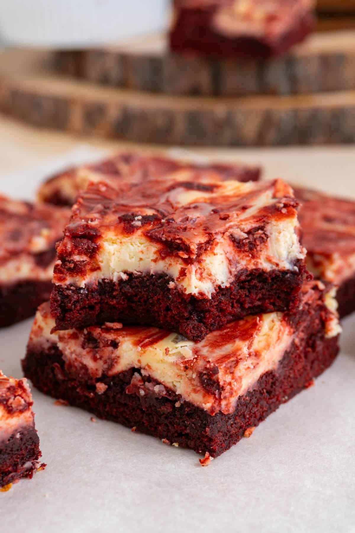 2 red velvet cheesecake brownies stacked, with the top one bitten