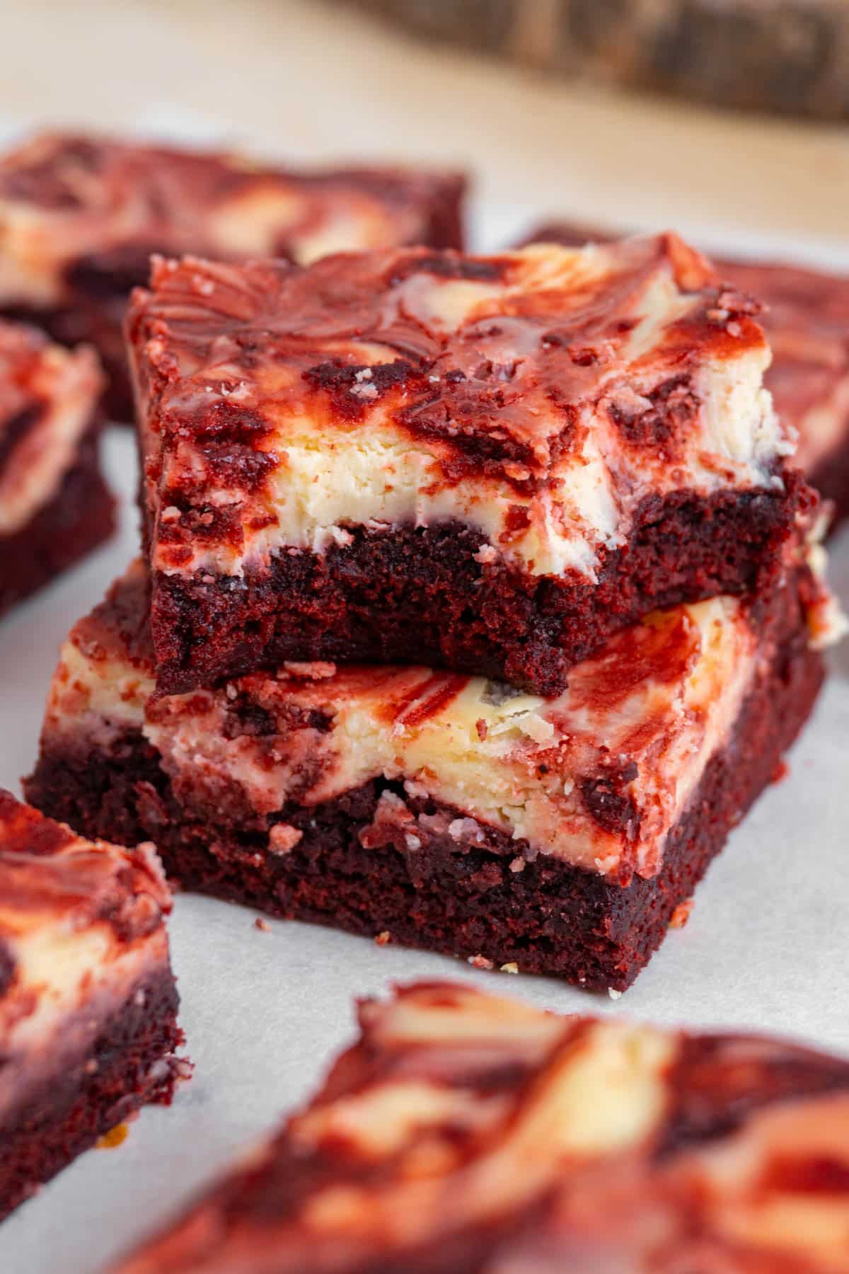 2 red velvet cheesecake brownies stacked, with the top one bitten