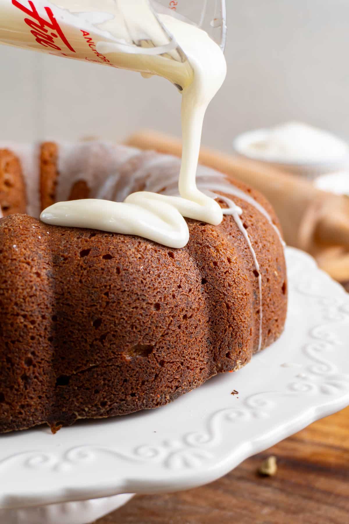 glaze being poured onto a bundt cake
