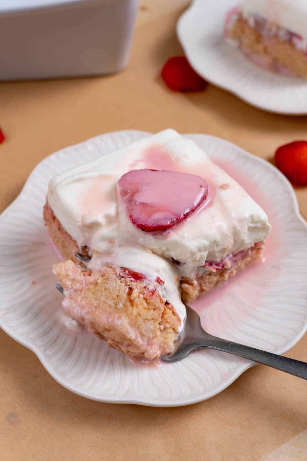 fork cutting into a slice of strawberry tres leches