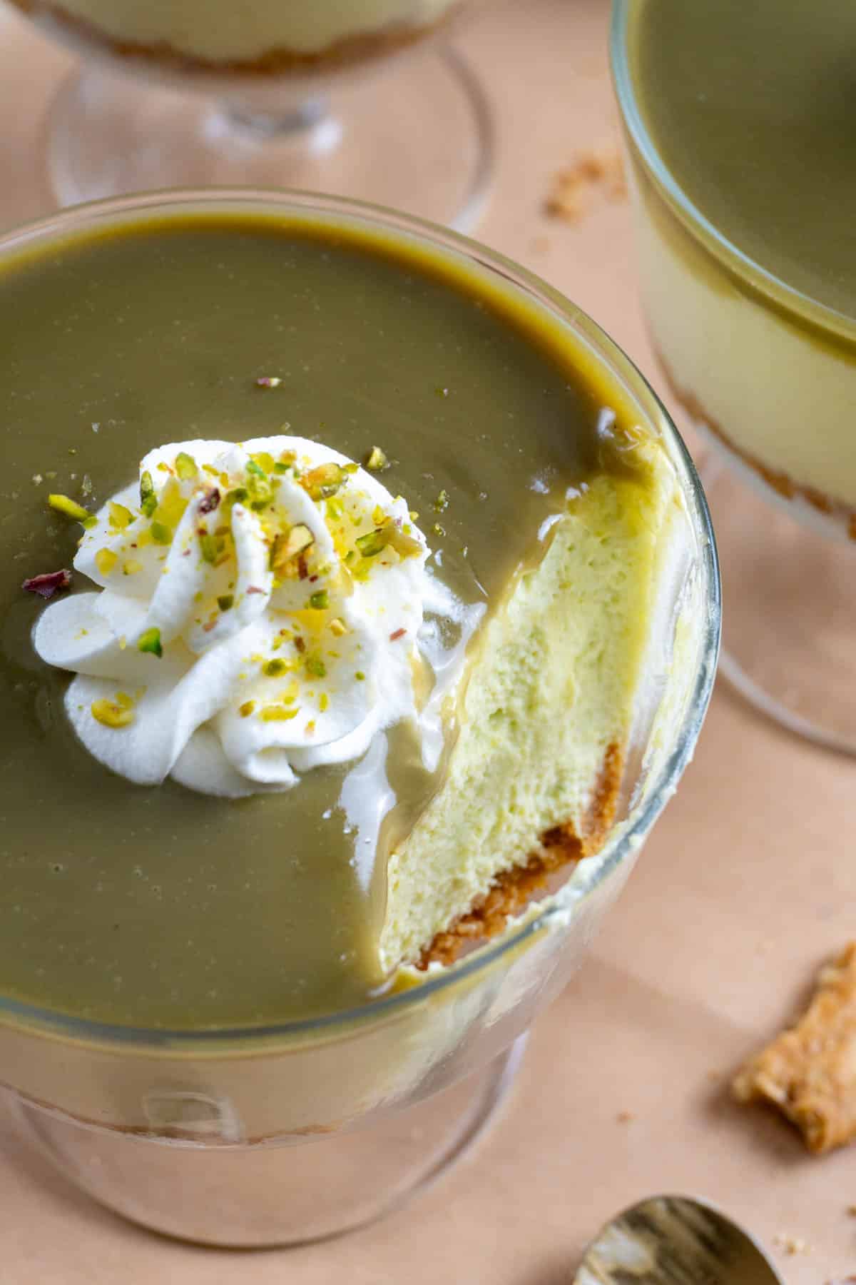 No bake pistachio cheesecake in a clear glass bowl with a bite taken out