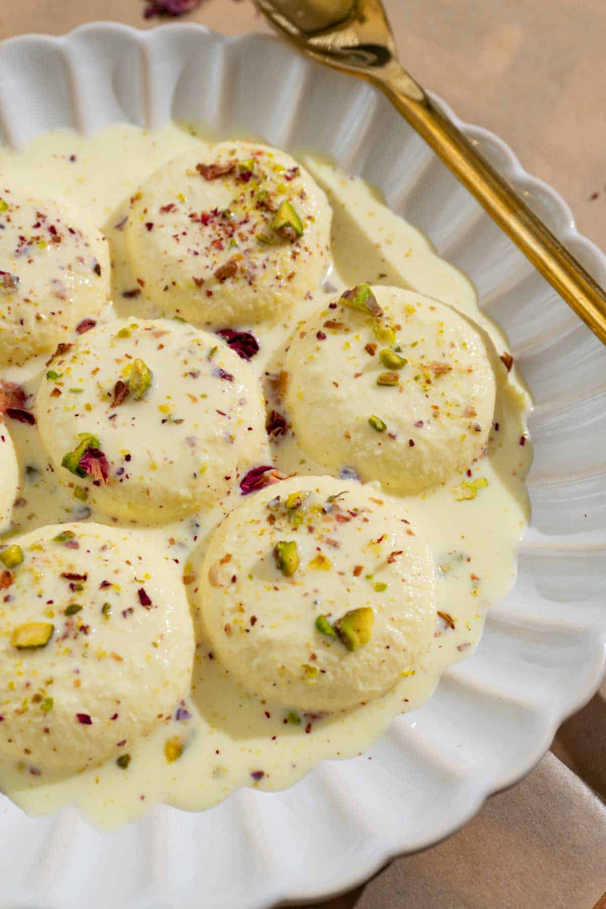 rasmalai in a white plate with a gold spoon